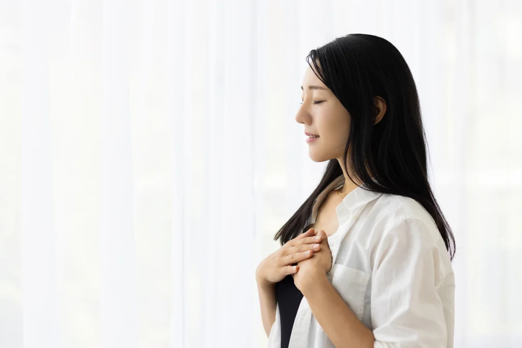 胸に手を当てる女性